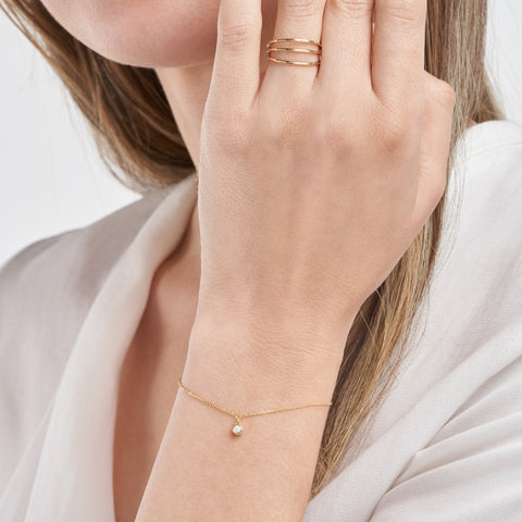 14k Yellow Gold Bezel Diamond Charm Bracelet on woman's wrist