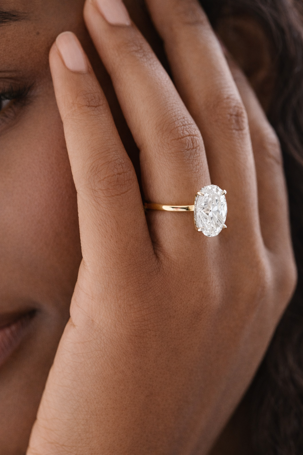 Close-up of a hand wearing a diamond ring with a blurred background