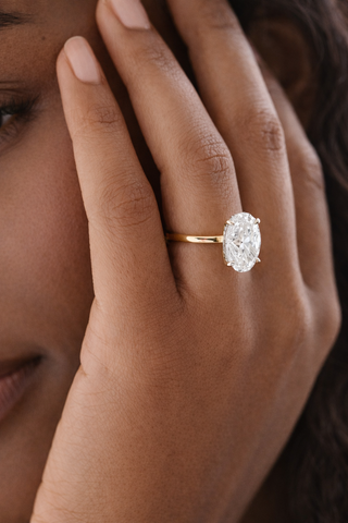 Close-up of a hand wearing a diamond ring with a blurred background