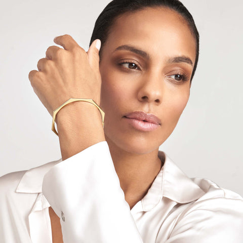 A woman wearing a white shirt and a gold ring