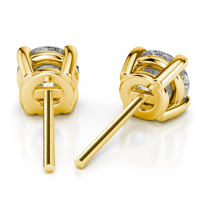 A pair of yellow gold earrings with a round diamond