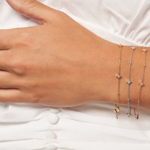 Three Gold Diamond Star Bezels and Beads Station Bracelet on woman's wrist