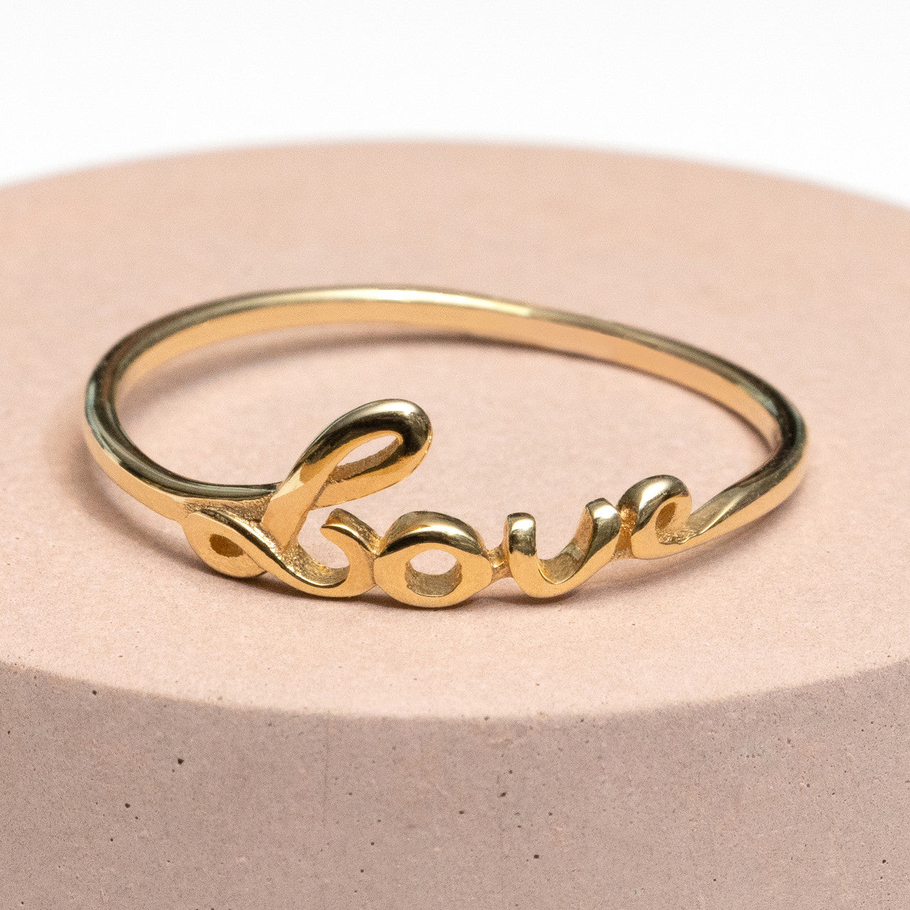 A gold ring with the word love on it