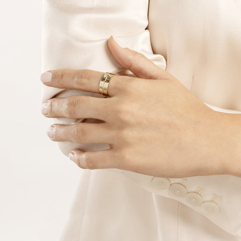 A woman in a white dress holding a gold ring